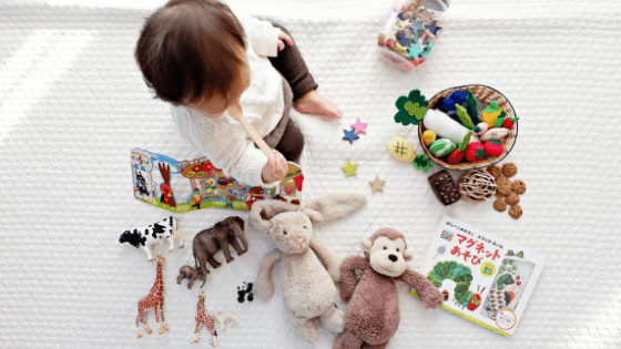 PirraSmith - bebe en manta con un montón de juguetes esparcidos